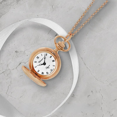 Classique Rose Gold Pendant Watch with Roman Numerals on display across a ribbon laying on a marble top.