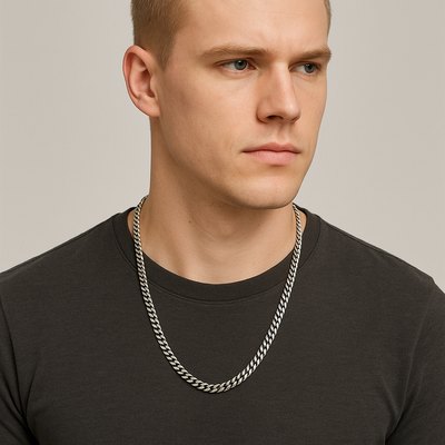 Blonde male model in a charcoal tee gazes sideways, the 55 cm stainless-steel curb chain resting below his collarbone, every beveled link catching soft studio light.