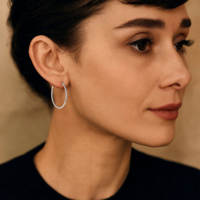 Close-up of a woman wearing 30mm Sterling Silver endless hoop earrings with a 1.5mm tube profile. The hinged closure creates a smooth, polished, and lightweight look.