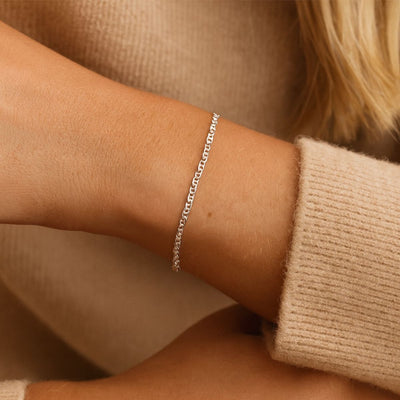 Close-up of a woman’s wrist wearing an 18cm Sterling Silver Anchor Chain Bracelet with 1.9mm x 3.7mm links, showcasing its elegant fit and secure parrot clasp.
