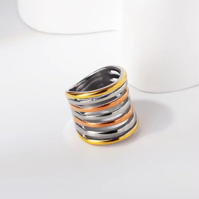 A stunning tri-tone spiral wrap ring featuring yellow gold, rose gold, and silver hues. A unique 18K gold-plated statement ring for bold styling.