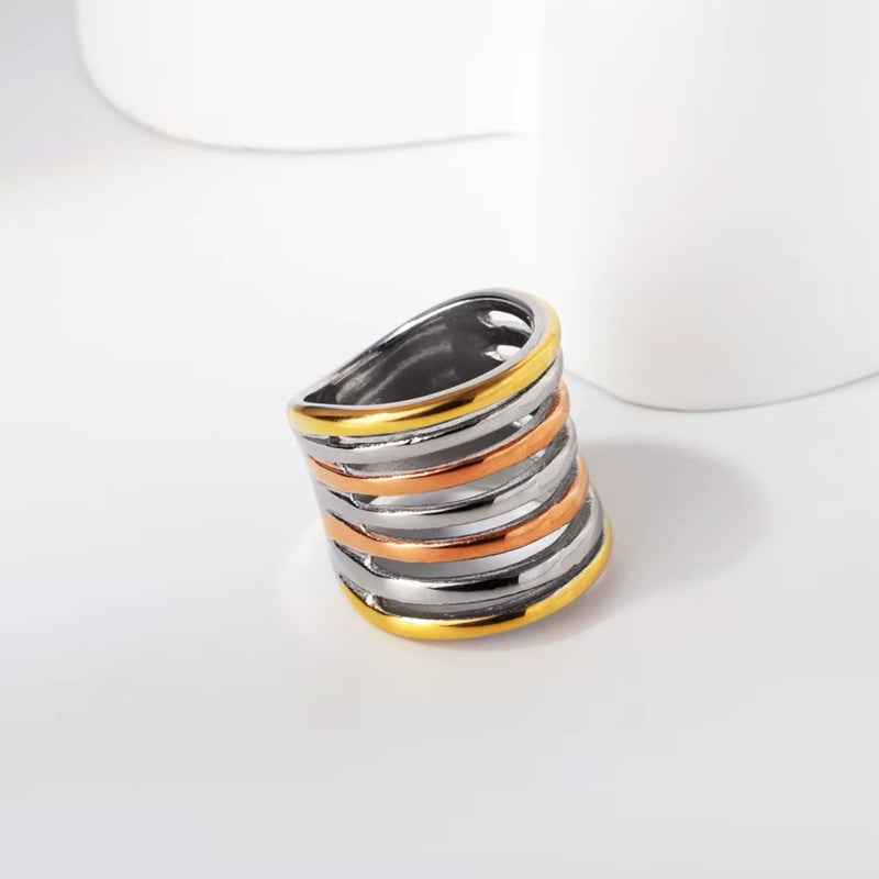 A stunning tri-tone spiral wrap ring featuring yellow gold, rose gold, and silver hues. A unique 18K gold-plated statement ring for bold styling.