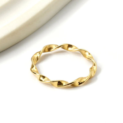 Beautifully displayed is our 2.4mm Twisted Wave Ring - A delicate 18K gold-plated stainless steel band with a smooth wave design. A versatile and elegant stackable ring.