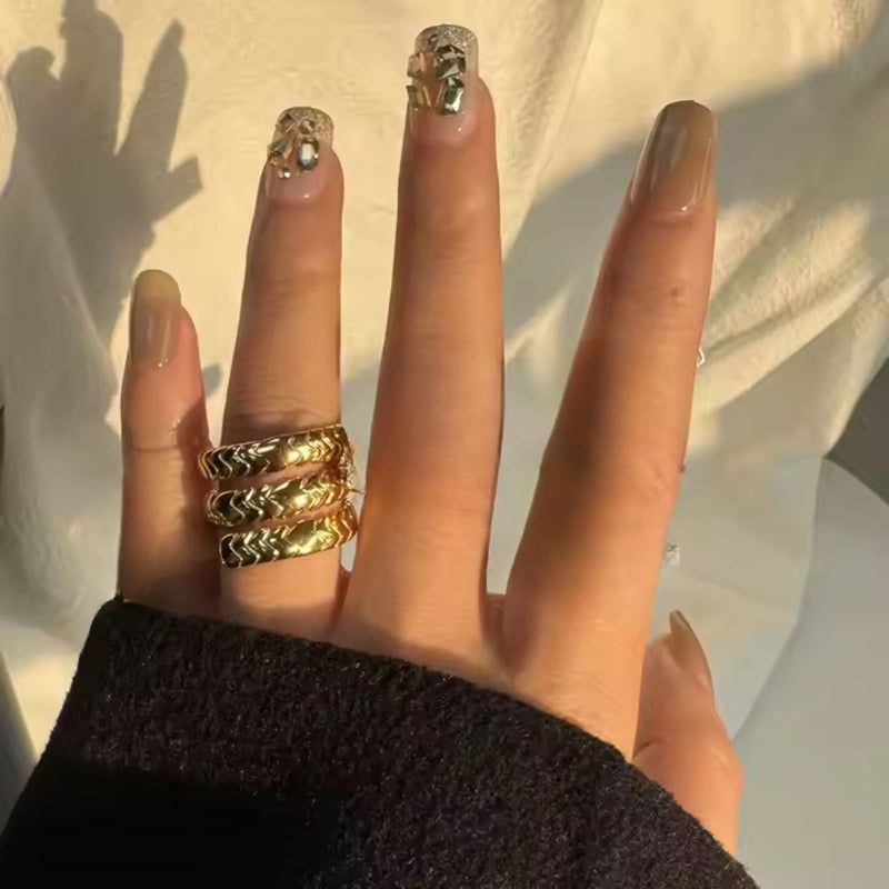 A stunning 18K gold-plated stainless steel wrap-around snake ring with an intricate scale design, coiling gracefully around the finger. The polished gold finish enhances its bold and elegant appeal.