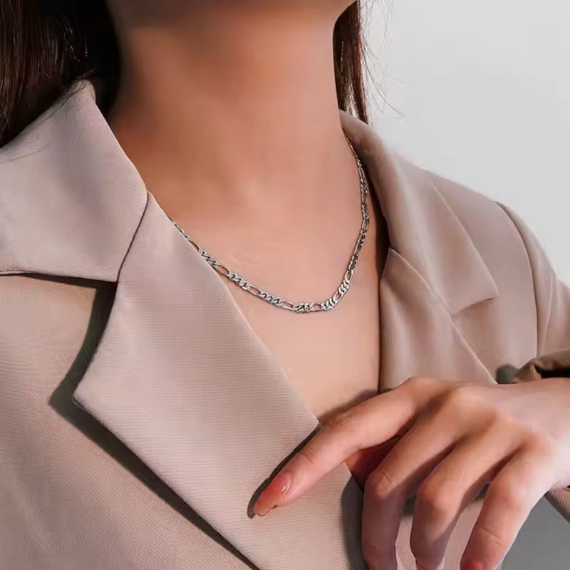 Model in a coat wearing the 3.3mm 3+1 Figaro chain necklace in 45cm sterling silver, showcasing alternating short and long links.