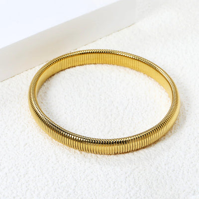 Close-up of the bangles’s fluid design, showcasing its seamless links and high-shine gold finish.