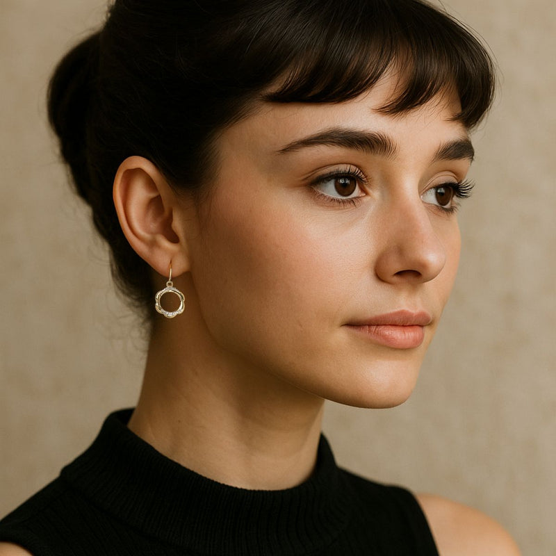 Elegant two tone 9ct gold petal-style circle earrings with diamonds, worn by a model with a natural background.