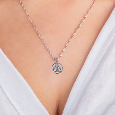 A model wearing the Aquarius Zodiac Charm Pendant on a sterling silver chain, showcasing the charm's sleek and personalised design, adding a stylish, zodiac-inspired touch to their everyday fashion.