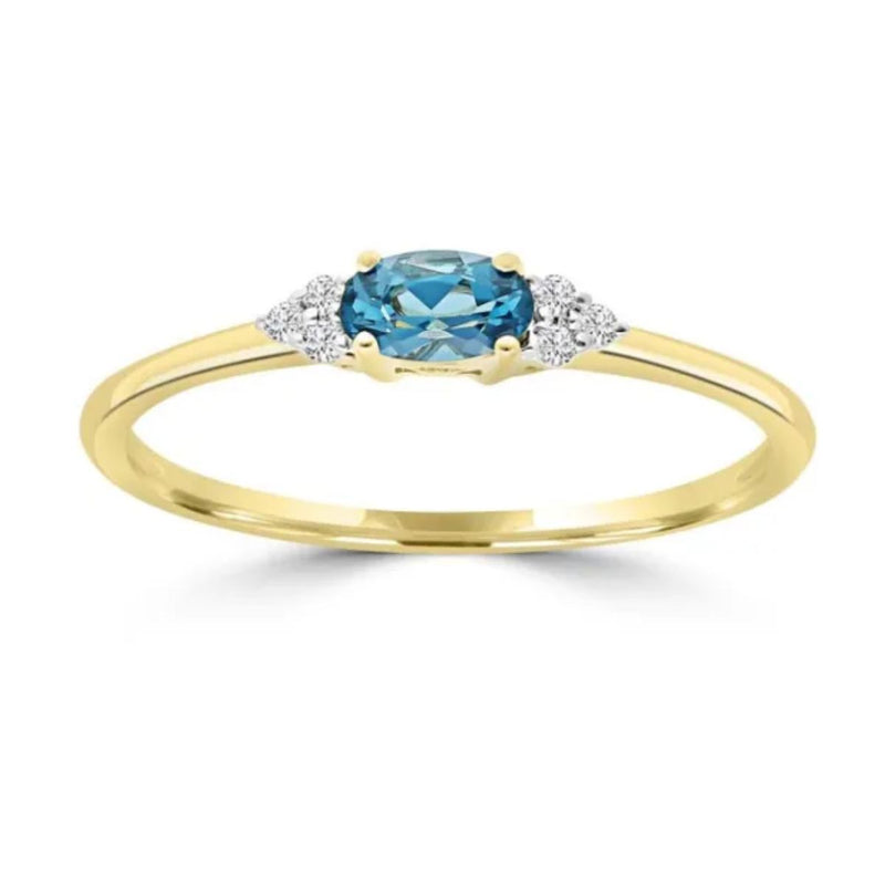 9ct Yellow Gold Ring with oval blue topaz and 0.03ct diamonds. Available from Jewels of St Leon.