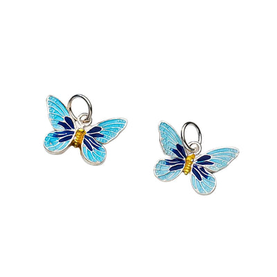 A pair of butterfly charm pendant displayed elegantly against a soft white background, emphasizing its vibrant enamel colours and 15x11mm size.