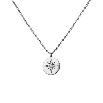 A close-up of the CZ Star Disc pendant reveals the fine cubic zirconia detailing, beautifully capturing light and adding sparkle to the subtle, polished silver disc.