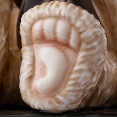 A close-up of the bear's paw, showcasing the finely textured fur pattern and the delicate hand-painted details that bring this figurine to life.