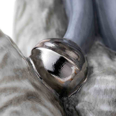 A detailed view of Frost’s silver bell, finished in real platinum. The shine of the bell complements the intricate hand-painted scarf and adds a luxurious touch to this exquisite collectible.