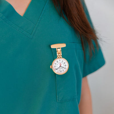 Classique Pro-Care Rose Gold Plated Nurses Watch pinned to nurse’s scrub top, showing white dial with black numerals.