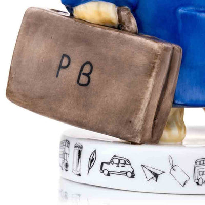 A zoomed-in view of Paddington's suitcase reveals its textured details and the engraved "P.B.," reflecting expert craftsmanship. The perfect representation of Paddington's travel adventures.