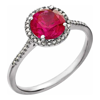 Our lab-created Ruby and Diamond Halo-Style Silver Ring is a perfect piece of ladies' jewellery. This top view shows the beauty of the 7mm Lab-Created Ruby and the beaded halo along with the 0.01ctw natural diamond accents in a beautiful sterling silver birthstone ring. Shop rings for women at Jewels of St Leon.