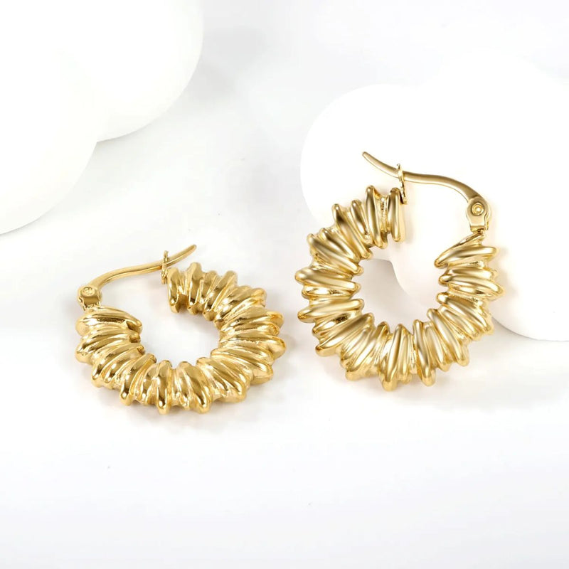 Alluring Close-Up of Twisted Hoops
A detailed close-up showcasing the elegant twisted design of the Chunky Irregularity Circle Hoops, highlighting the gleaming 18K PVD Gold Plating.