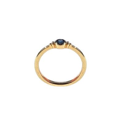 A side view of the ELLIN Ring, capturing the profile of the 3.75mm blue sapphire and the fine craftsmanship of the 9kt yellow gold band, showcasing its smooth finish and sophisticated style. Shop gold rings from Jewels of St Leon.