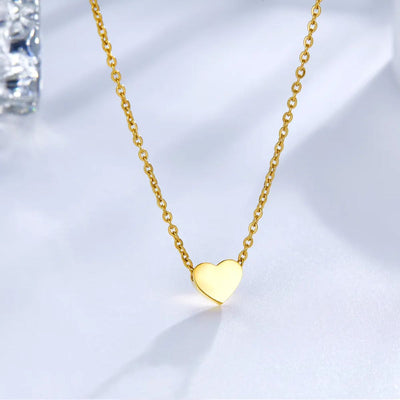 The gold heart necklace elegantly displayed on a soft background, showcasing its sleek 45cm chain, engraved charm, and polished finish.