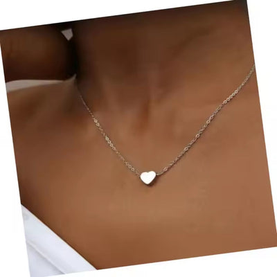 The stainless steel heart necklace gracefully displayed on a models neck, high lighting its modern aesthetic and customisable charm.