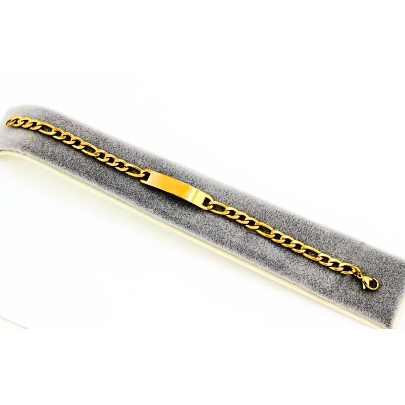 The Gold Engravable Bracelet draped elegantly across a bracelet display, highlighting its polished finish, bold Figaro chain, and versatile appeal.