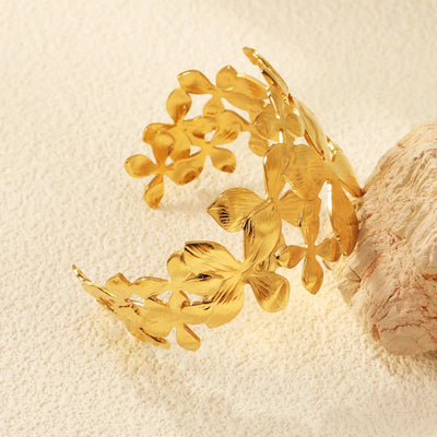 A close-up of the intricate flower pattern, highlighted by its 18K Gold Plated Finish. The cuff bracelet is hypoallergenic, waterproof and sweat-proof for a more durable and longer-lasting shine.