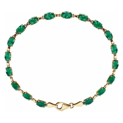 Introducing our exquisite Lab-Created Emerald Bracelet, a radiant tribute to May's birthstone. Crafted in luxurious 14kt yellow gold, this bracelet boasts timeless elegance and sophistication. Measuring 18cm long and secured with a lobster clasp, it offers both style and security for everyday wear. Adorned with 18 6x4mm oval lab-grown emeralds, each stone is meticulously set to showcase its vibrant green hue and beauty. 