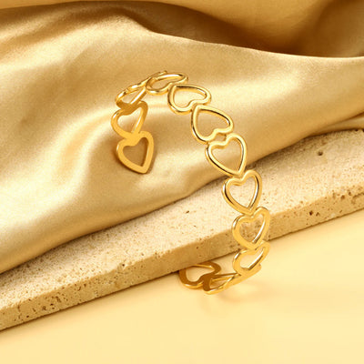 A sleek open heart gold cuff bracelet in 18K gold plated Stainless Steel for a timeless appeal, that is durable, hypoallergenic, waterproof and tarnish resistant. Sitting on a silk cloth and marble stone to show off its true beauty.