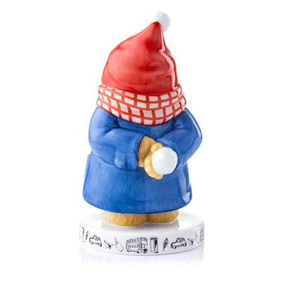 Paddington Bear First Snowball Figurine rear view - You can see Paddington Bear holding a snowball, while wearing a Santa hat, Scar, Blue Duffle and showcasing iconic London Motifs around the base.