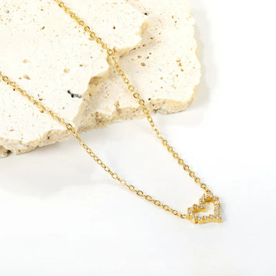 Heart necklace gently draped across smooth white sandstone pieces, creating a soft, romantic setting that highlights its delicate charm.