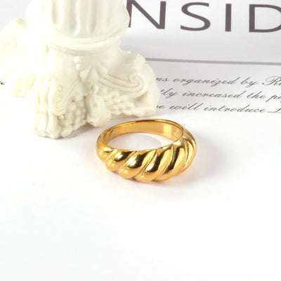  A stylish 18K gold-plated stainless steel croissant ring with a curved design artistically displayed. A trendy women’s statement ring inspired by modern fashion.