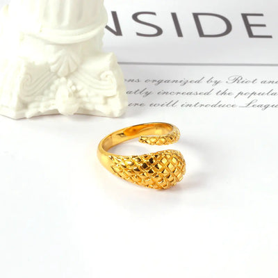 A detailed 18K gold-plated stainless steel snake ring with a tapered design beautifully displayed. A unique wrap-around ring with bold and elegant craftsmanship.