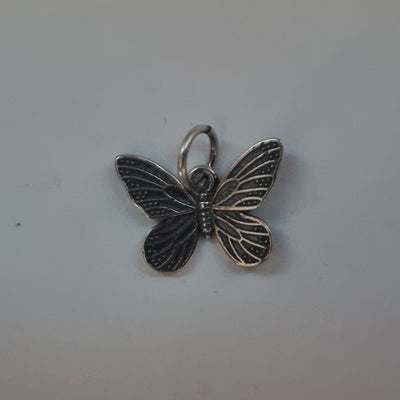 A close-up of the Silver Oxidised Butterfly Charm Pendant, showcasing its intricate details and contrasting light and dark tones that highlight the oxidised finish.