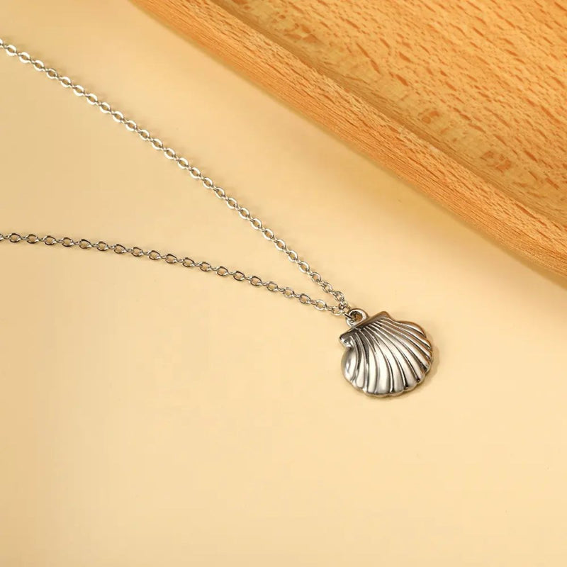 Silver Shell Necklace displayed against a neutral backdrop, highlighting the soft shine of the stainless steel and the fine shell detailing.