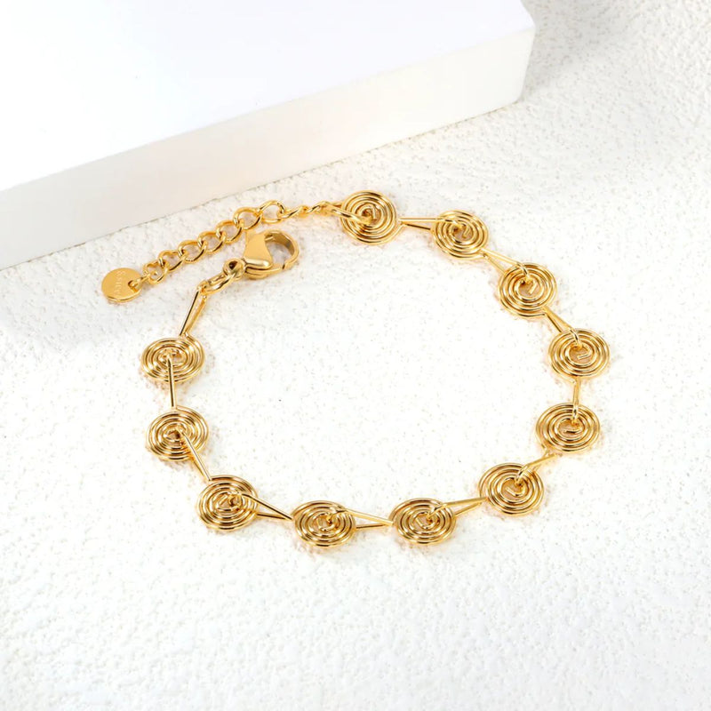 Close-up of the finely crafted spiral charm, highlighting its intricate design and polished gold finish.