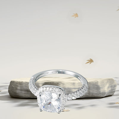 Close-up of a 925 Sterling Silver ring featuring a 5 mm cushion-cut cubic zirconia centre stone surrounded by a halo of micro CZs, resting against a stone