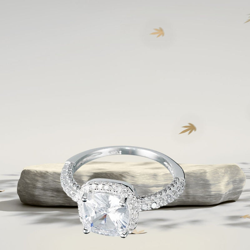 Close-up of a 925 Sterling Silver ring featuring a 5 mm cushion-cut cubic zirconia centre stone surrounded by a halo of micro CZs, resting against a stone