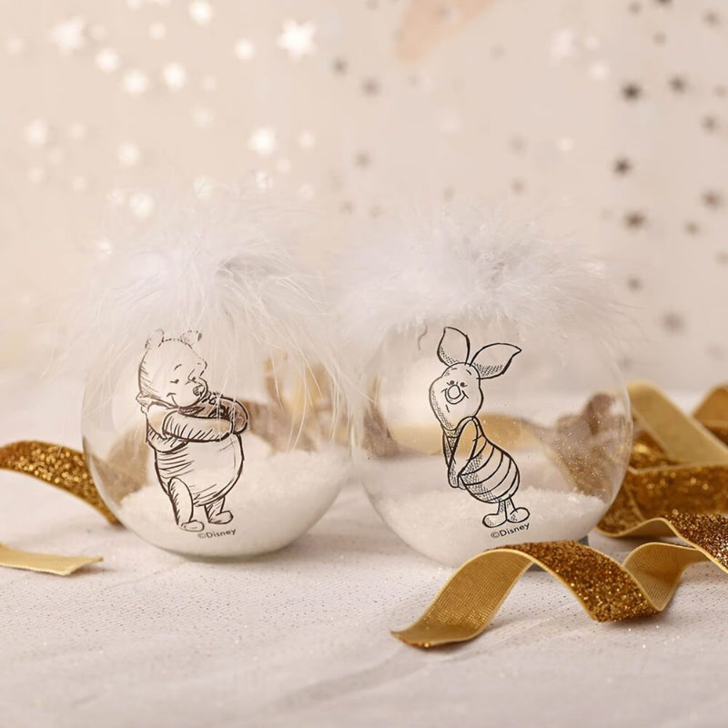 Winnie the Pooh and Piglet Disney collectible Christmas bauble set with feathers and gold ribbon on a festive background.