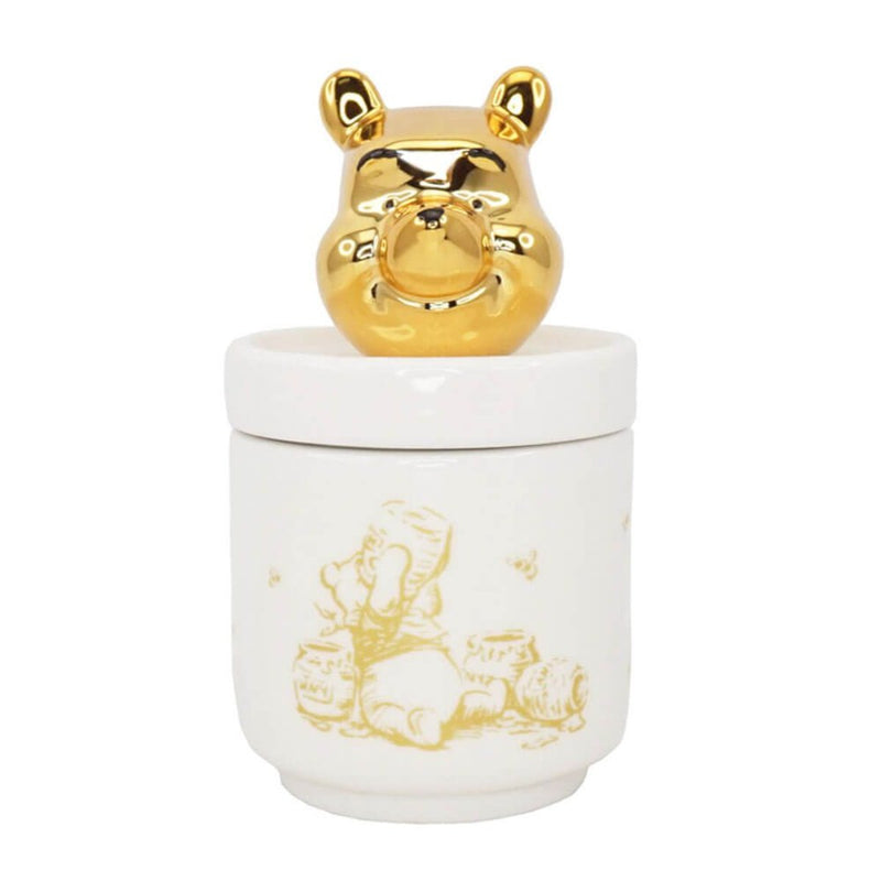  A close-up of the Disney Winnie the Pooh Collector’s Box lid showcasing a gleaming gold Pooh head and a whimsical illustration of Pooh enjoying honey.