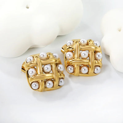 Overhead set-up of woven gold pearl earrings beside minimalist ceramic shapes, emphasising modern square silhouette and scattered pearls.