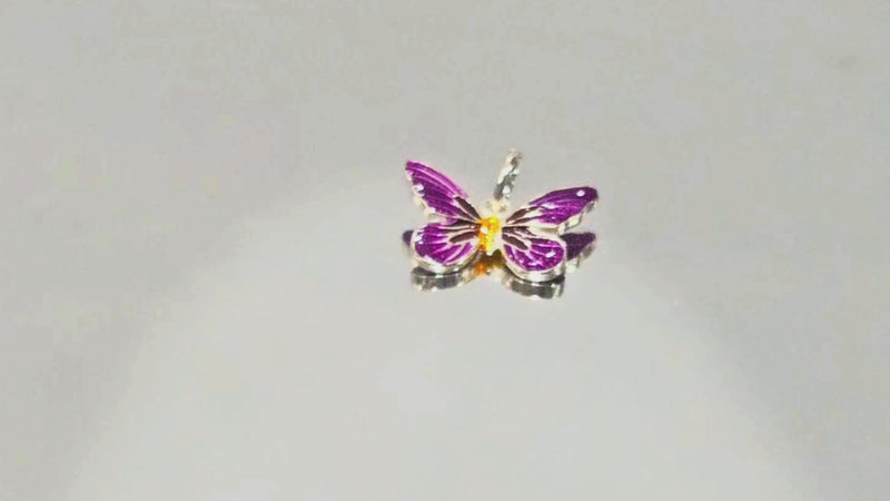 Purple Enamel Silver Butterfly Charm Pendant Video: Admire the intricate craftsmanship of our Purple Enamel Silver Butterfly Charm Pendant. A stunning mix of soft purple hues and gold highlights on sterling silver, this delicate charm is the perfect addition for lovers of nature and elegance.