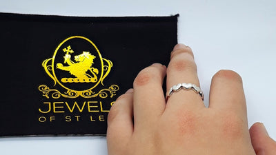 Connected Heart Ring being worn with a Jewels of St Leon Jewellery cloth at the side.