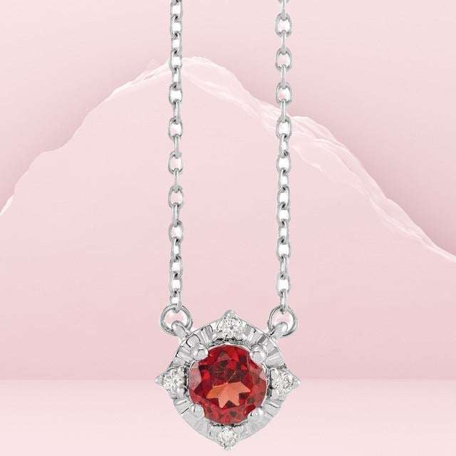 The Sterling Silver Natural Mozambique Garnet & .04 CTW Natural Diamond Halo-Style 45cm Necklace is a stunning piece of jewellery that features a natural garnet stone as its centrepiece. The pendant measures 8.5x5.1mm in size and is surrounded by a halo style, including .04 CTW natural diamonds. The necklace is made of rhodium-plated 925 sterling silver, ensuring its durability and long-lasting shine. Available from Jewels of St Leon Online Silver Jewellery.