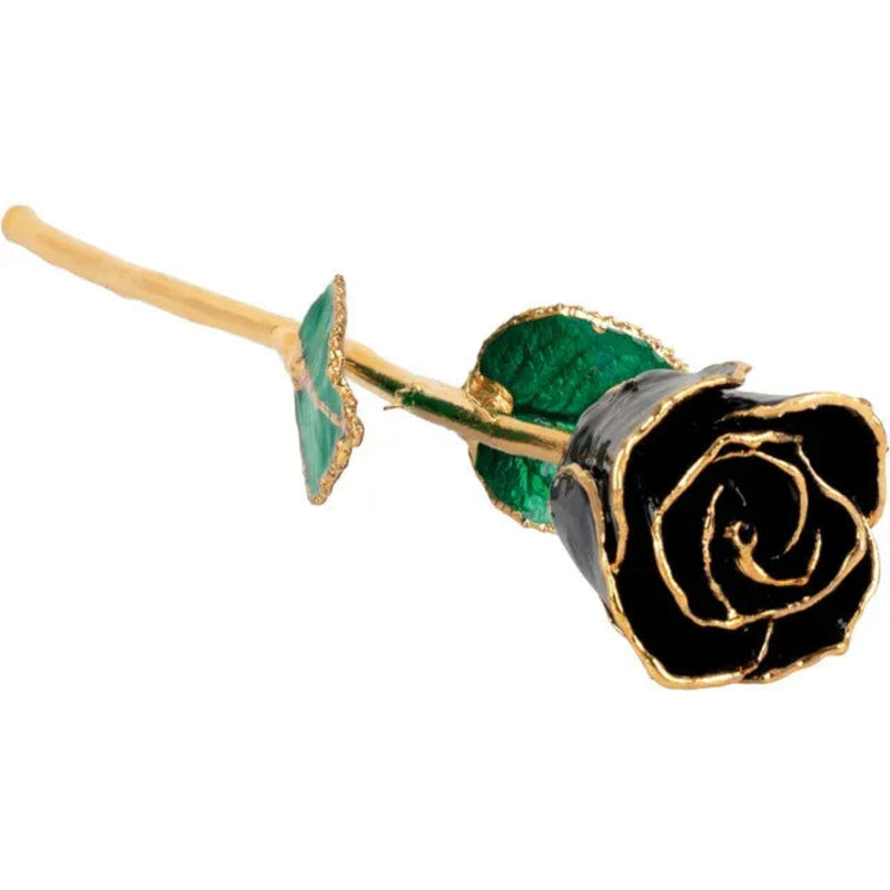 Black lacquered rose on its side with gold-trimmed head in the foreground.