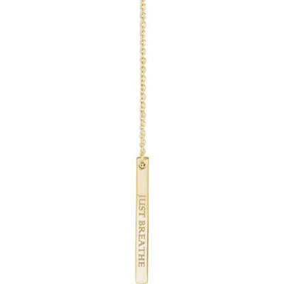 The 14K Gold Engravable Bar Necklace engraved with "Just Breathe," beautifully displayed dangling from an adjustable cable chain. A simple yet meaningful accessory with a timeless shine.