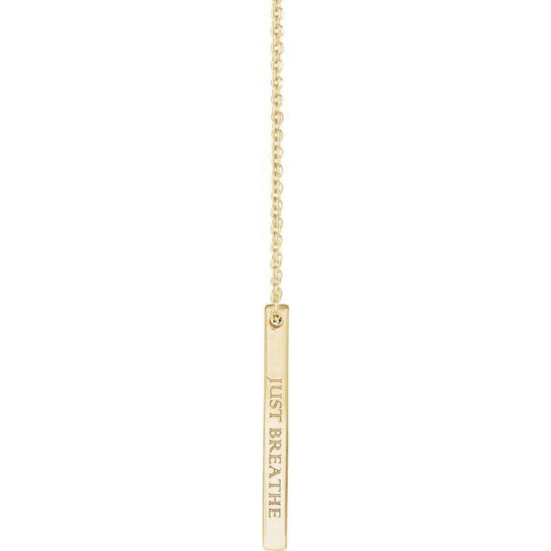 The 14K Gold Engravable Bar Necklace engraved with "Just Breathe," beautifully displayed dangling from an adjustable cable chain. A simple yet meaningful accessory with a timeless shine.